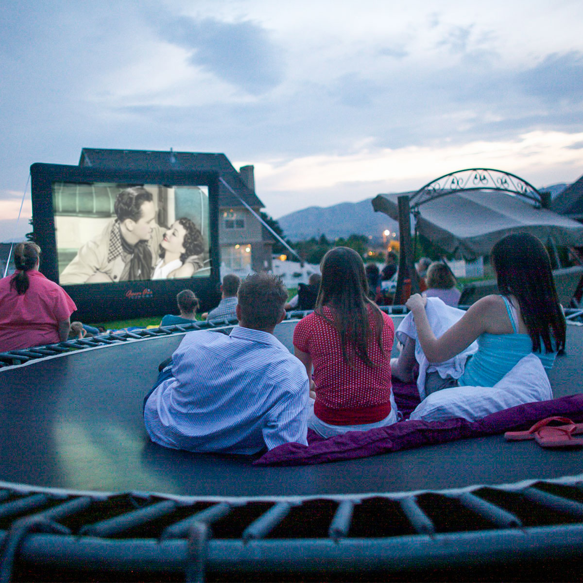 Open Air Cinema Standard 12' inflatable screen with family in a backyard